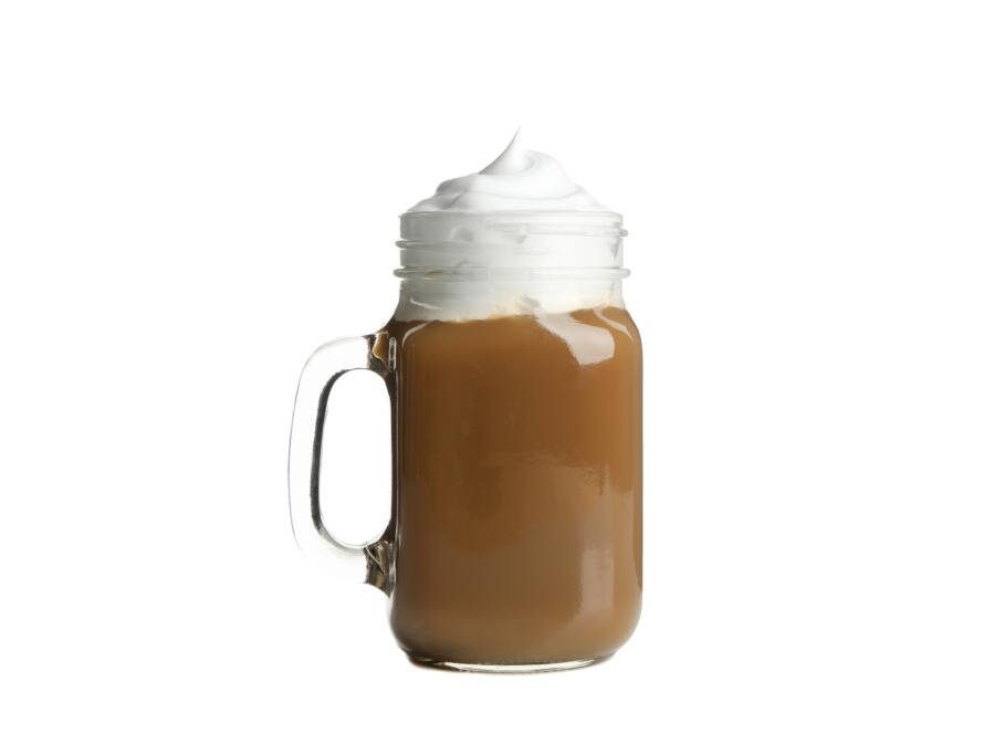 Iced coffee with poured cream isolated on white background